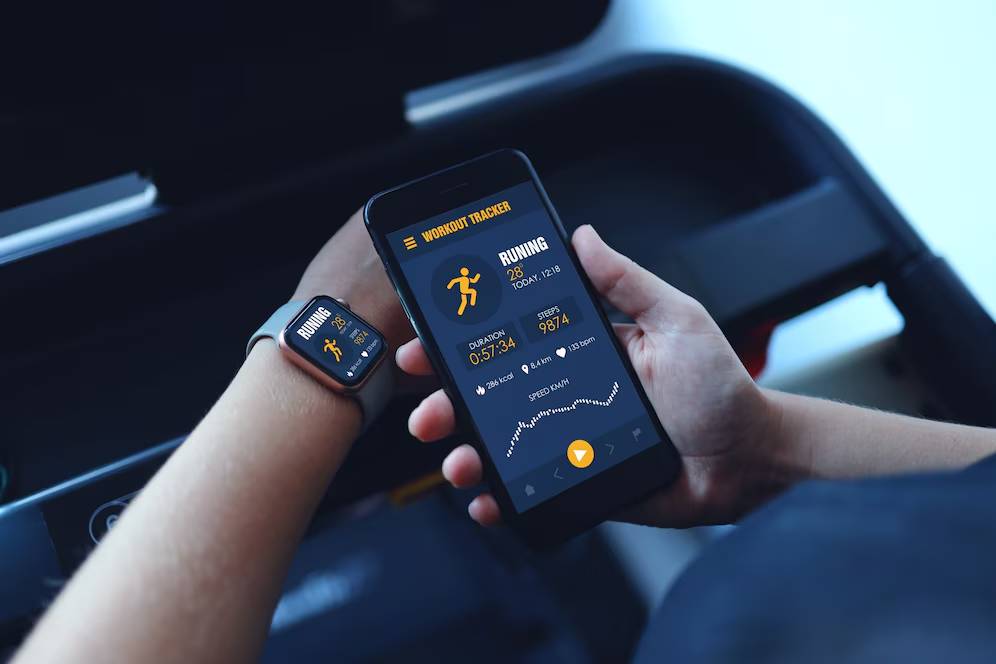 Person using a smartwatch and smartphone with running tracker apps in a car.