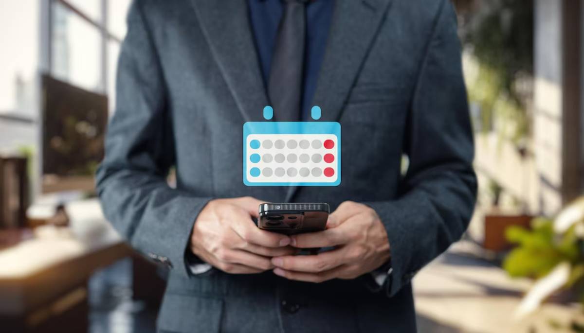 Businessman holding smartphone, cartoon speech bubble with calendar icon overlaying his face.