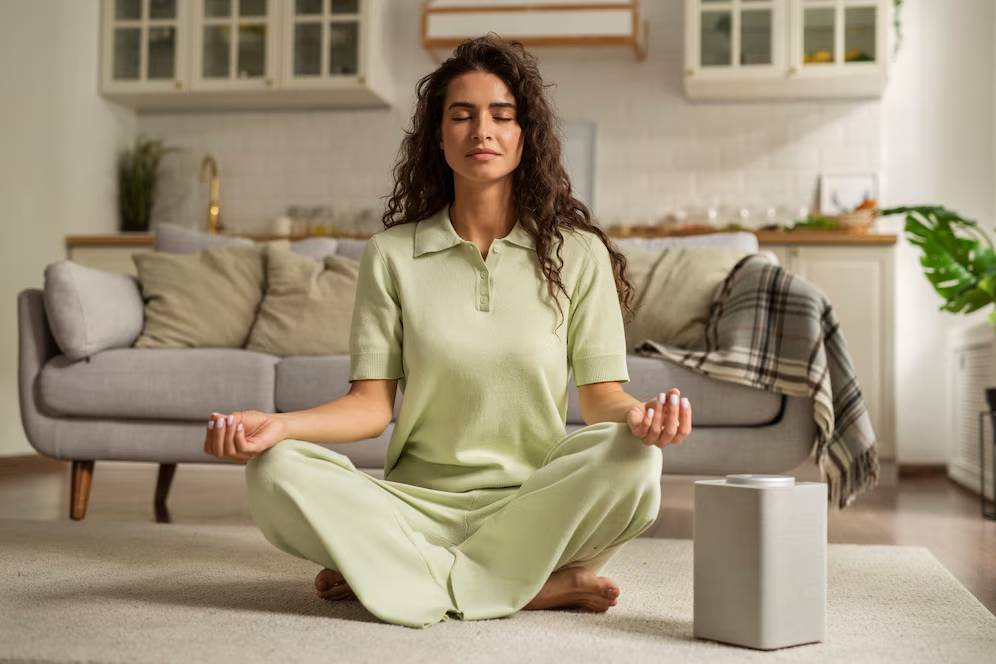 Woman meditating in a lotus pose in a serene living room environment.