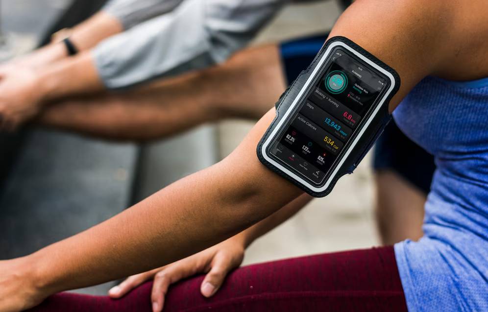 A person wearing a smartphone armband that displays fitness tracking information during exercise.